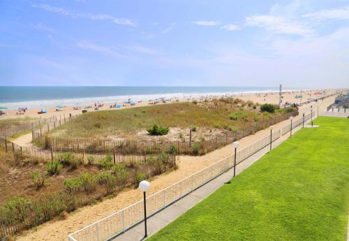 a walkway to the beach with people on the beach at Dunes Suites Oceanfront in Ocean City