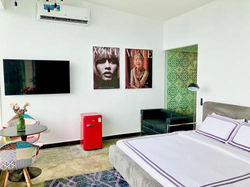 a bedroom with a bed and a chair and a table at Epic Suites Bohol ADULTS ONLY in Dauis
