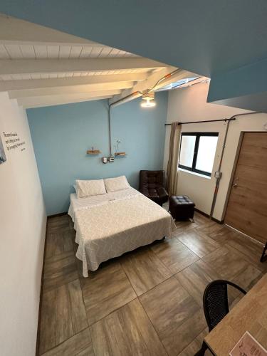 a bedroom with a bed in a room with blue walls at CoLinkHouse Hotel in Medellín