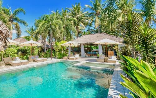 een zwembad met stoelen en parasols in een resort bij L'Archipel in Gili Air