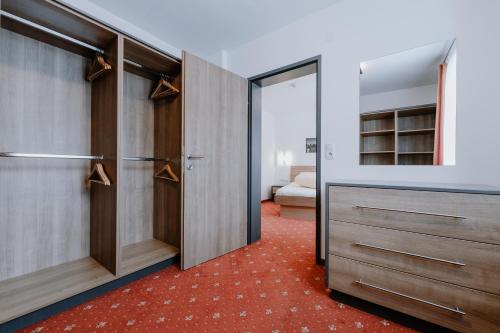 a walk in closet with wooden doors and a red carpet at Appartement Sporthütte Fiegl in Sölden