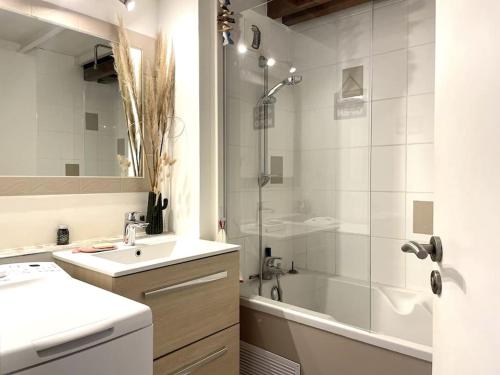 a white bathroom with a sink and a shower at Duplex Bord De Mer in Le Croisic