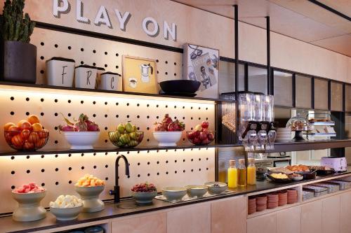 a kitchen with many bowls of food on shelves at Moxy Sydney Airport in Sydney