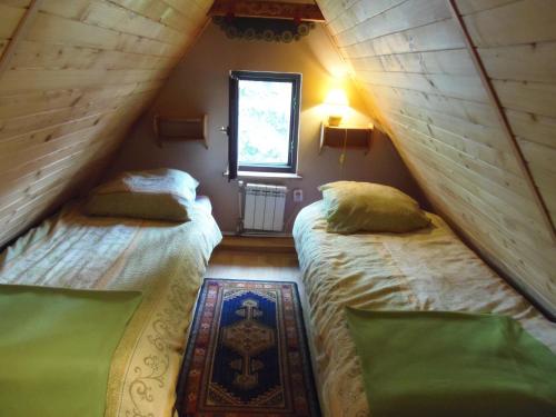 two beds in a small room with a window at Pokoje Jola Zakopane in Zakopane