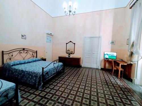 a bedroom with a bed and a desk and a television at Etna in Belpasso
