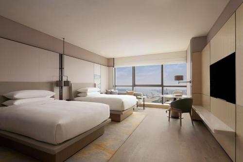 Cette chambre comprend deux lits et une télévision. dans l'établissement Shantou Marriott Hotel, à Shantou