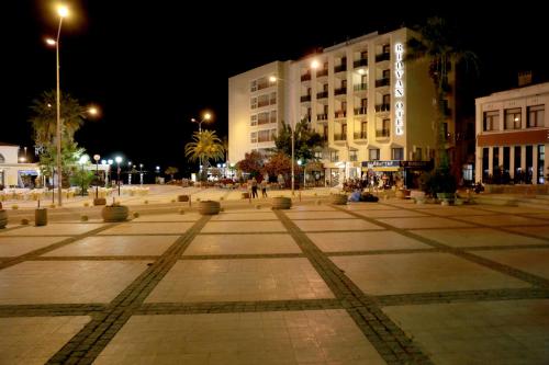 a square in a city at night with buildings at Rıdvan Hotel in Cesme