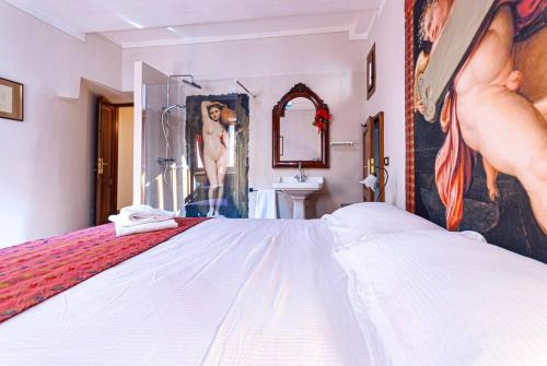 a bedroom with a bed and a sink and a mirror at Artist's Suites in Spoleto