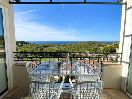 a table and chairs on a balcony with a view of the ocean at T3 vue mer exceptionnelle au domaine Frégate Bandol in Saint-Cyr-sur-Mer