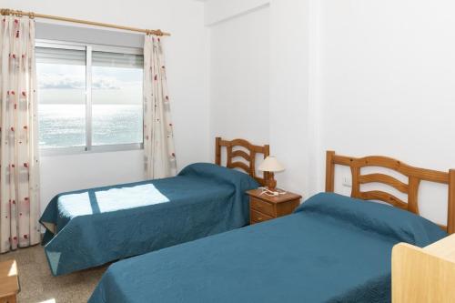 クリェラにあるSanta Marta, Iii-A 7º-16のベッドルーム1室(ベッド2台付)、海の景色を望む窓が備わります。