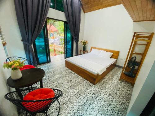 1 dormitorio con 1 cama, mesa y sillas en Homestay Bài Văn garden, en Ba Vì