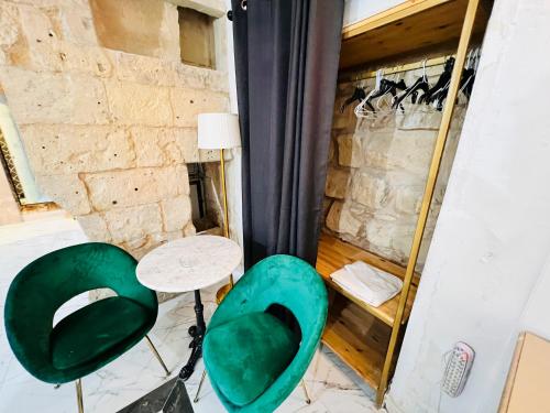 une chambre avec deux chaises vertes et une table dans l'établissement Charming Townhouse Prime Area Valletta, à La Valette