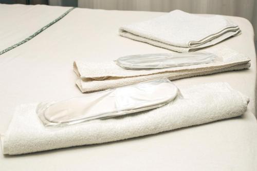 a pile of white towels on a bed at Kaynarca Butik Hotel in İznik