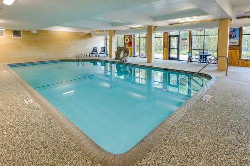 a large swimming pool with blue water in a building at Cozy Alpine Escape Ski-InandOut at Lutsen Mtns in Lutsen