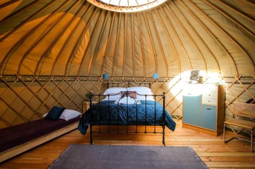 a bedroom in a yurt with a bed in it at Wye Glamping in Velindre