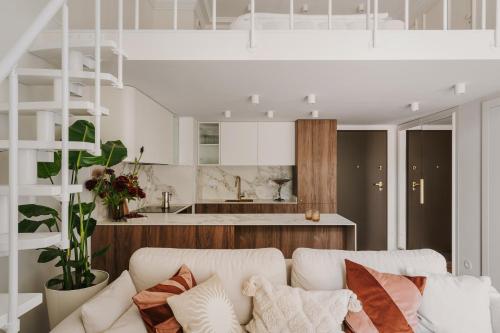 een woonkamer met een witte bank en een keuken bij Przy Przystani Apartament Paryski in Wrocław