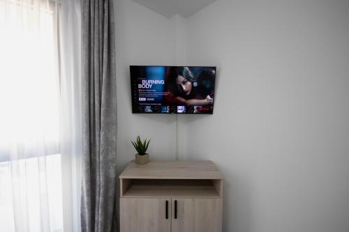a living room with a tv on the wall at DownTown Apartments in Rădăuţi
