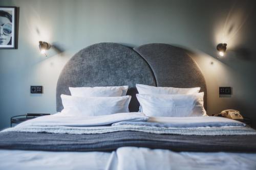 a bed with a large headboard with white sheets and pillows at The Circus Hotel in Berlin