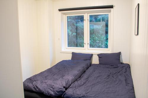 a bed in a room with a window at Modern Fjord View Apartment in Tromsø