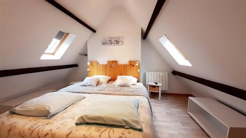 ein Schlafzimmer mit einem Bett und zwei Oberlichtern in der Unterkunft La Beuvrequentoise 1 in Beuvrequen
