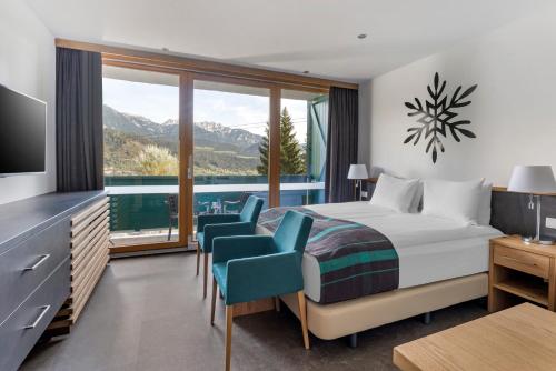 a bedroom with a bed and a view of the mountains at Alpine Club in Schladming