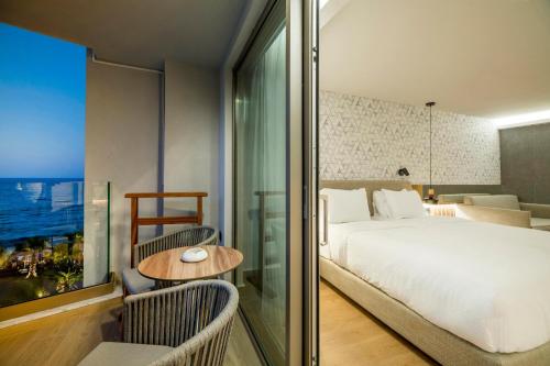 a hotel room with a bed and a table and chairs at AKASHA Beach Hotel & Spa in Hersonissos