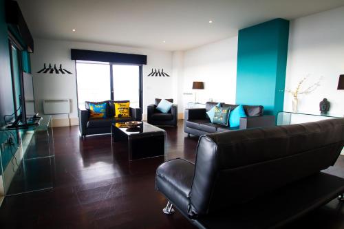 a living room with two couches and a table at Merchant Quarters Apartments in Liverpool