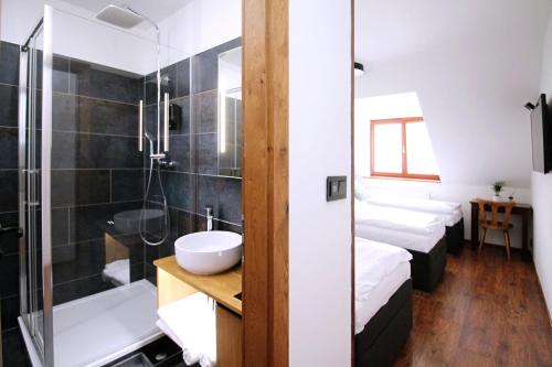 baño con 2 camas, ducha y lavamanos en Penzion u Zajíčku en Horákov