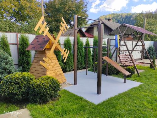 una zona de juegos en un patio con estructura de madera en Нота Карпат, en Skole