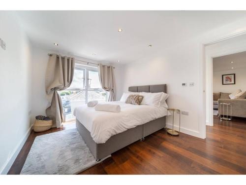 a bedroom with a bed and a large window at Gwel An Keynvor Penthouse in Newquay