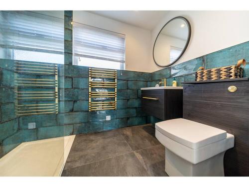 La salle de bains est pourvue de toilettes et d'un miroir. dans l'établissement Gwel An Keynvor Penthouse, à Newquay