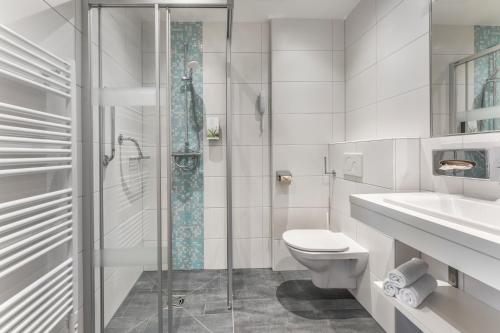 ein Bad mit einem WC, einem Waschbecken und einer Dusche in der Unterkunft Alpine Club in Schladming
