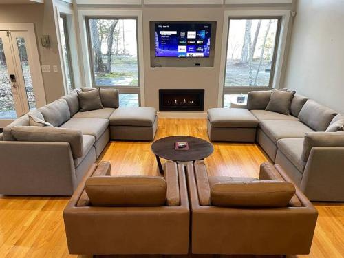 a living room with two couches and a tv at Luxury Modern Waterfront Retreat in Montross