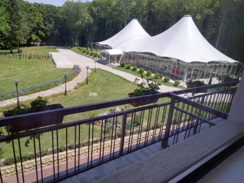 uma varanda com vista para um jardim com tendas brancas em Hotel Kovanlika 2 em Razgrad
