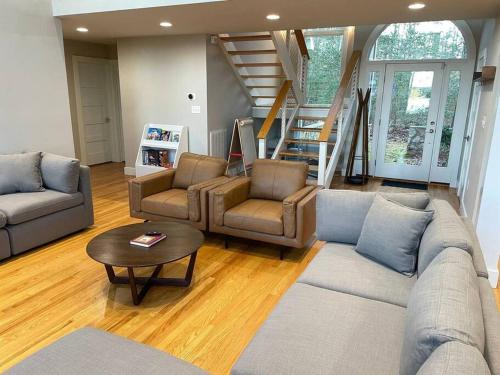 sala de estar con sofá, sillas y mesa en Luxury Modern Waterfront Retreat, en Montross