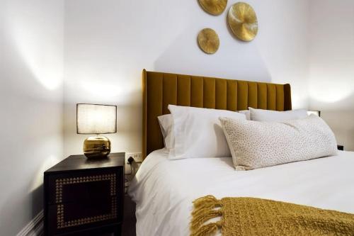 um quarto com uma cama branca e uma cabeceira em madeira em Belle Vue Regency King size w Free Parking em Cheltenham