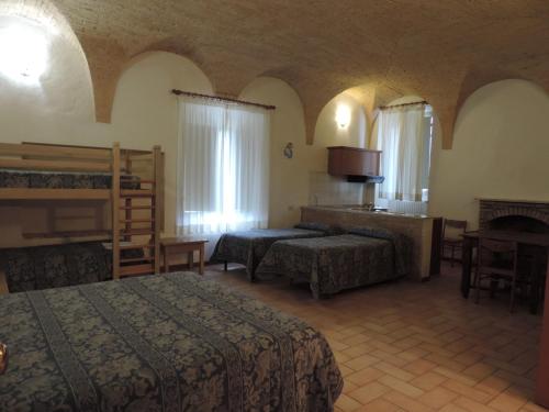 スポレートにあるCasa Religiosa di Ospitalità San Ponzianoのベッド2台とテーブルが備わるホテルルームです。