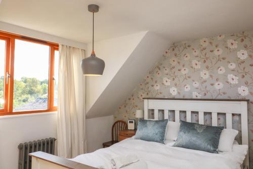 a bedroom with a bed with flowers on the wall at Mulberry Cottage in Totnes