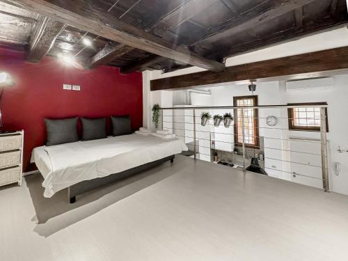 1 dormitorio con cama grande y pared roja en Realkasa Bolognetti Apartment, en Bolonia