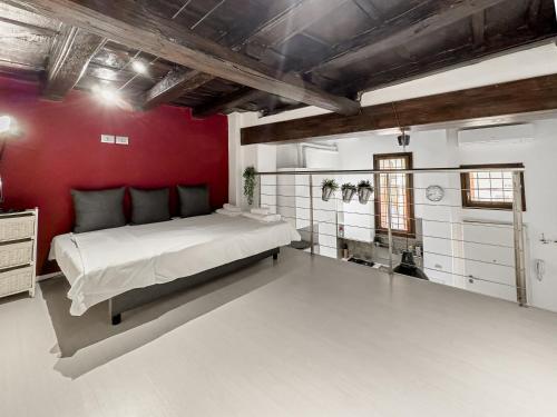 een slaapkamer met een groot bed en een rode muur bij Realkasa Bolognetti Apartment in Bologna