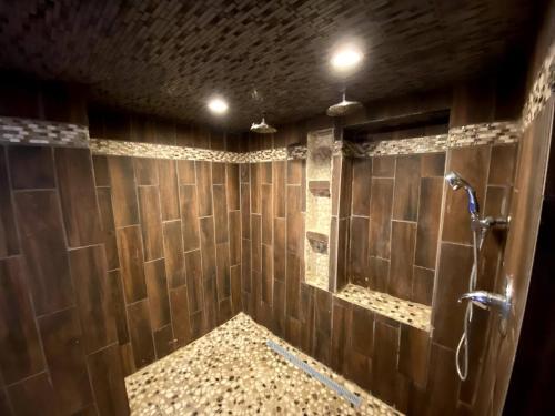 a bathroom with wooden walls and a shower with a mirror at Lexington Getaway in Lexington