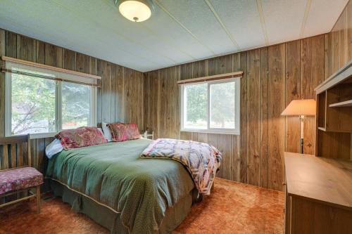a bedroom with a bed with wooden walls and windows at Cozy Salmon Home with Mountain Views and River Access in Salmon