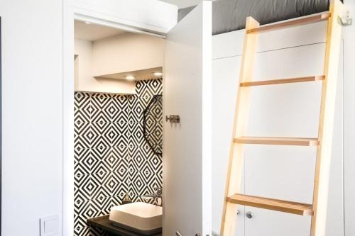 La salle de bains est pourvue d'une échelle et de toilettes. dans l'établissement Brochant - Cosy studio parc des batignolles, à Paris
