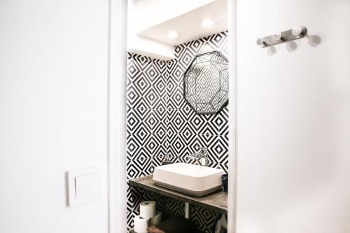 La salle de bains est pourvue d'un mur noir et blanc à motifs. dans l'établissement Brochant - Cosy studio parc des batignolles, à Paris