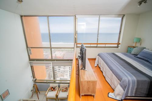 a bedroom with a bed and a large window at Hermoso loft en Iquique in Iquique