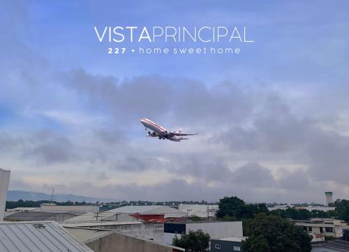 an airplane is flying in the sky over a city at Peaceful and Relaxing Home in Guatemala City in Guatemala