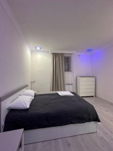 Un dormitorio con una gran cama negra y una ventana en Family Guest House en Ereván