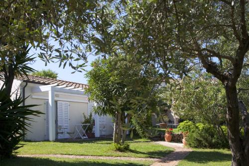 a white house with trees in the yard at Hotel Santo Stefano in Portoferraio