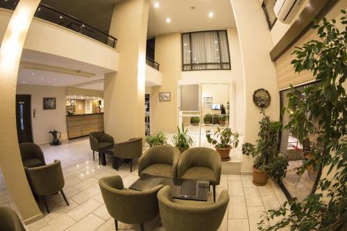a lobby with chairs and a table in a building at Rıdvan Hotel in Cesme
