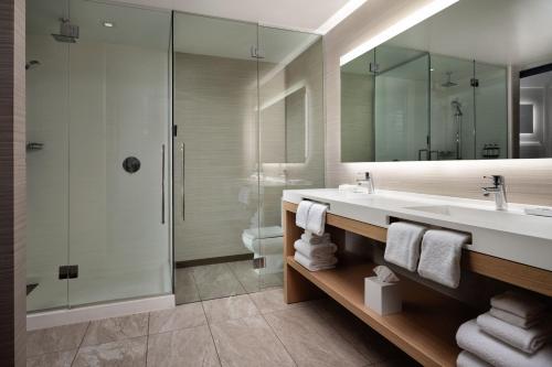 uma casa de banho com um lavatório, um chuveiro e um espelho. em AC Hotel by Marriott Phoenix Downtown em Phoenix